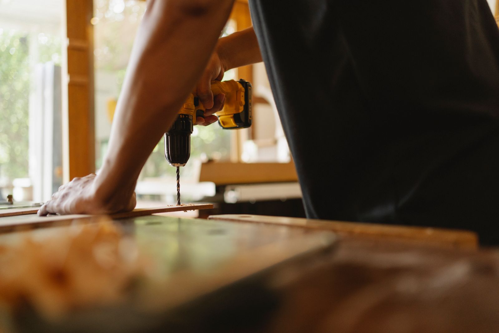 Handwerker bohrt bei einer Renovierung ein Brett an die Wand