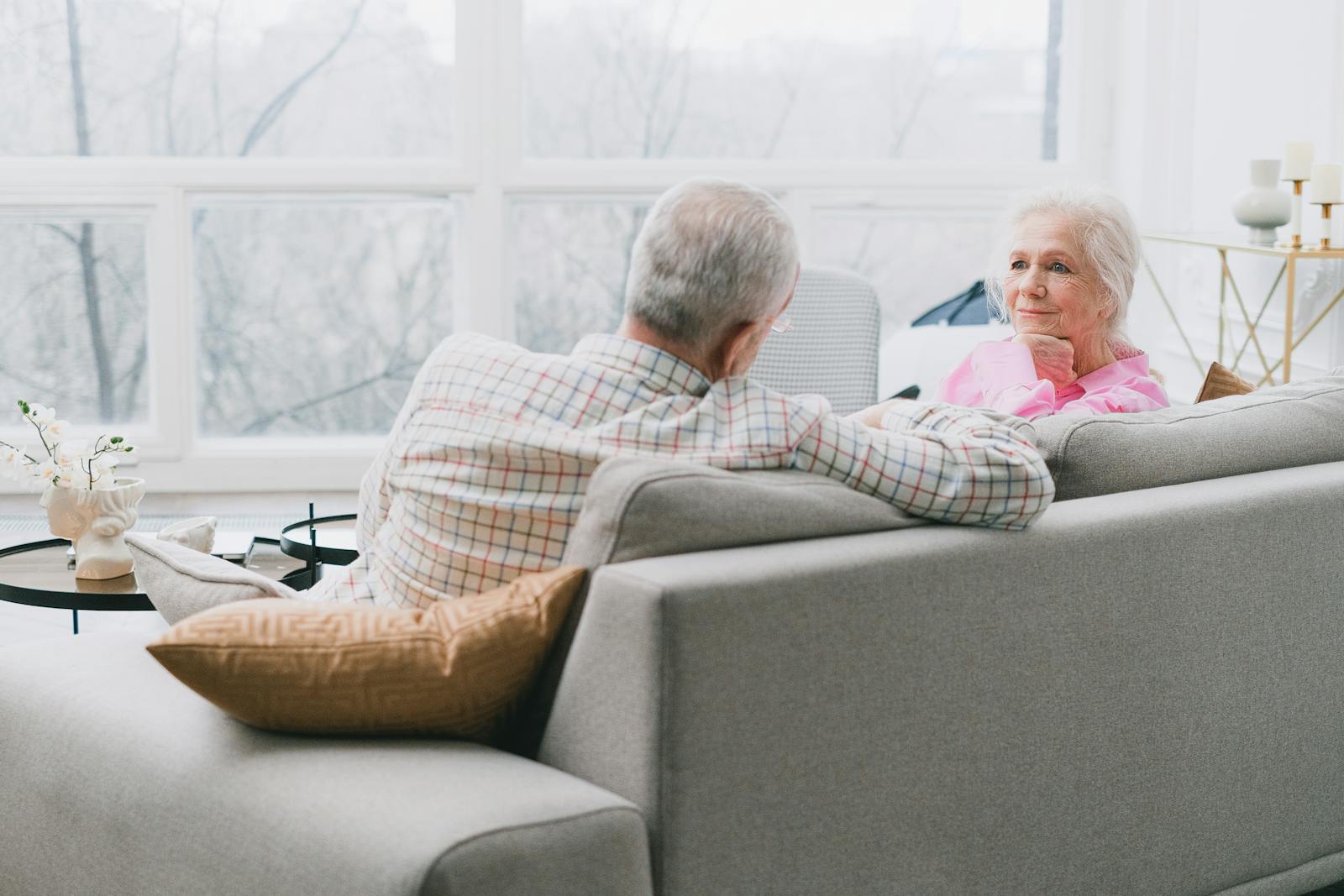 Älteres Paar sitzt nachdenklich zu Hause auf dem Sofa
