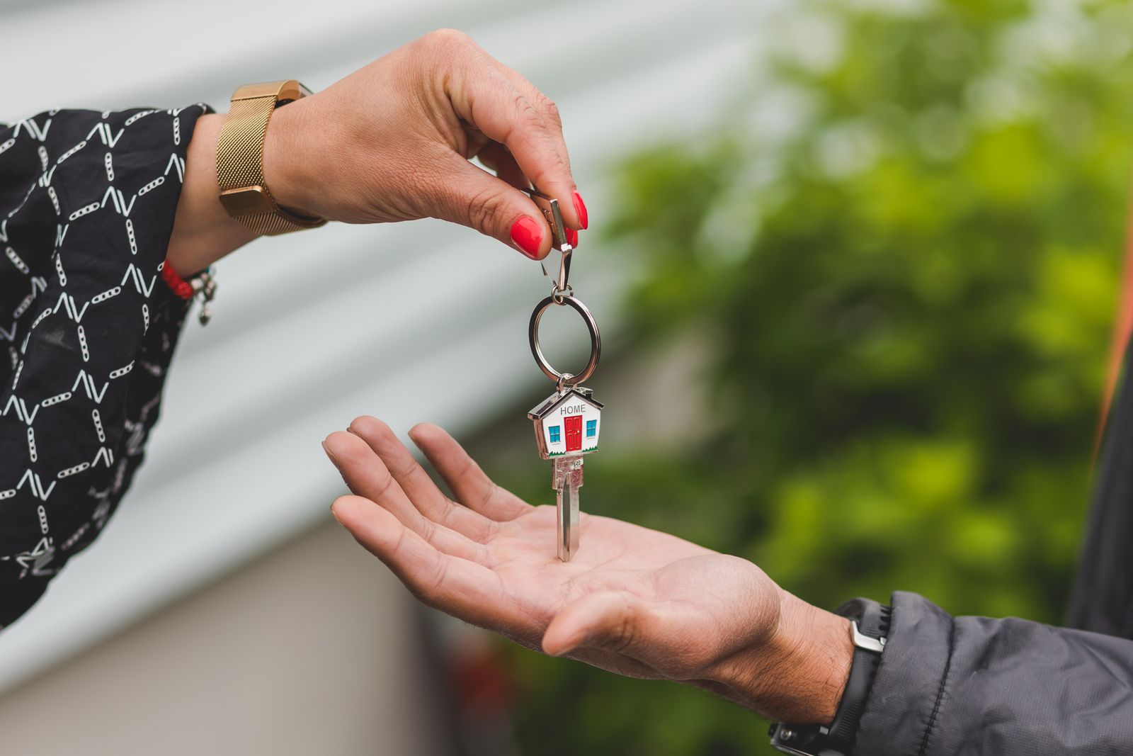 Schlüsselübergabe mit Haus-Schlüsselanhänger – Verkauf einer Immobilie