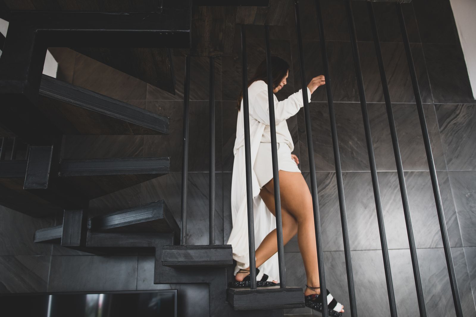 Frau geht eine elegante Treppe mit Handlauf hinunter