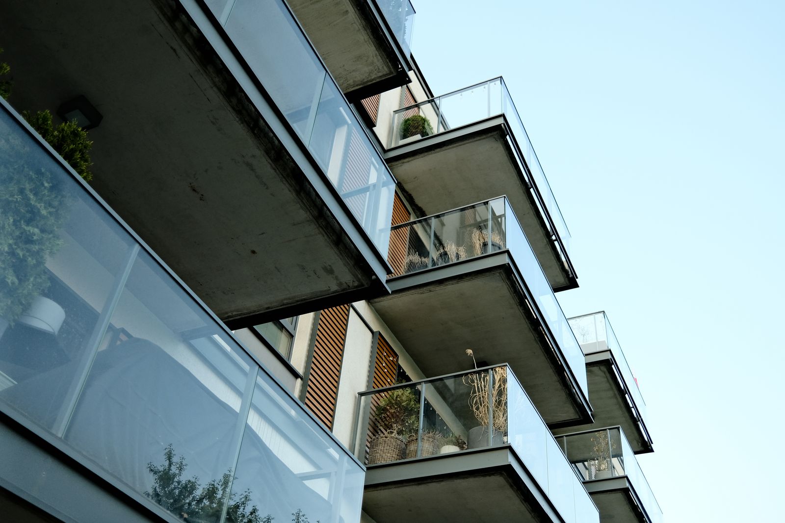 Moderne Wohnhausfassade mit Glasbalkonen bei Tageslicht